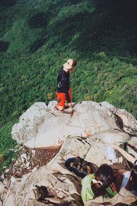 High angle view of smiling young woman standing on mountain