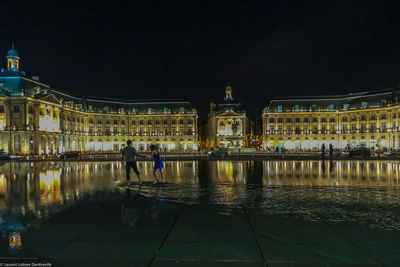 Reflection of illuminated buildings in water at night