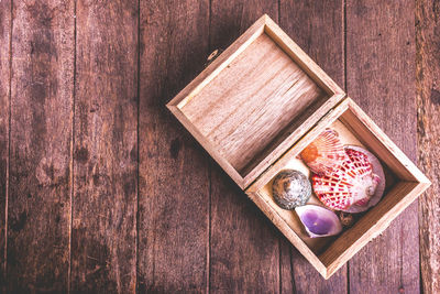 Directly above shot of seashells in wooden box on table