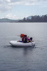 Man in boat at lake against sky