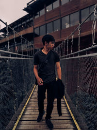 Full length of man standing on footbridge