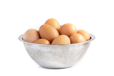 Close-up of eggs in bowl against white background