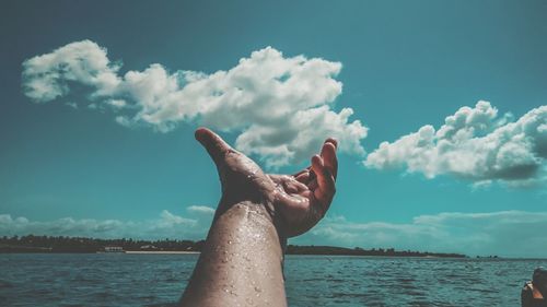 Midsection of person in sea against sky