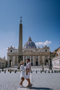 Full length side view of couple standing against church