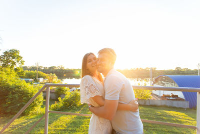 Young couple standing against sky