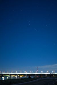 Illuminated bridge against sky at night