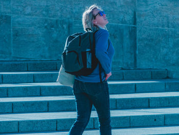 Full length of teenage woman standing against wall