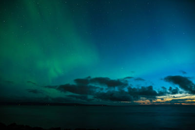 Aurora borealis at the sea shore, with sunset