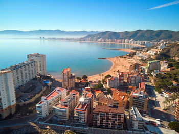 High angle view of buildings by sea against sky