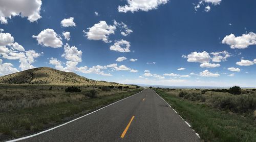 Road by landscape against sky