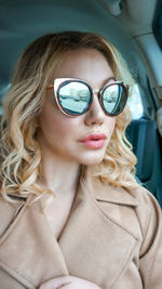 Woman in car wearing sunglasses with reflection