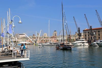 Sailboats moored at harbor