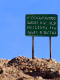 Close-up of information sign against clear blue sky