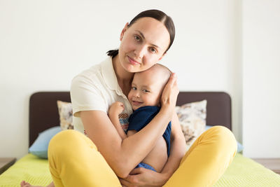 Portrait of mother and baby sitting on table