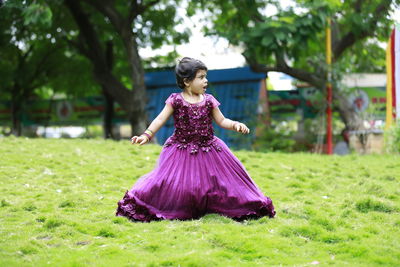 Full length of girl on purple while standing on field