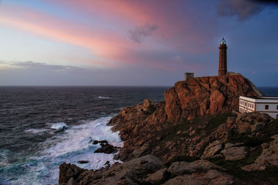 Lighthouse at cabo vilan on the galician coast in a colourful sunset . galicia, spain.