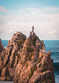 Rock formations by sea against sky