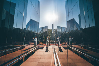 Woman standing amidst glass building