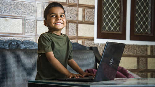 Portrait of boy using mobile phone at home