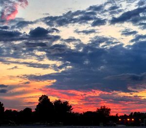 Silhouette of trees against dramatic sky