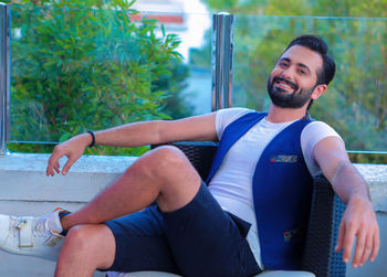 Portrait of smiling young man sitting outdoors