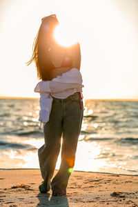Rear view of woman standing at beach