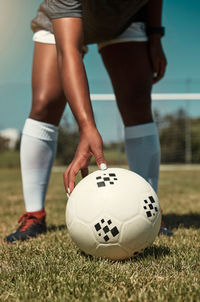 Low section of man playing soccer on field