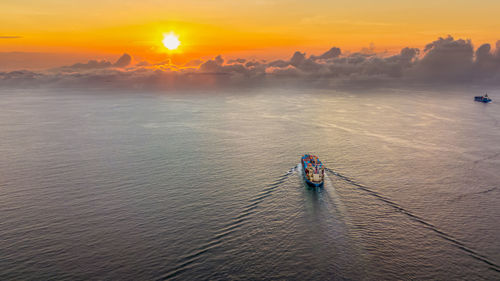 High angle view of boat sailing in sea during sunset