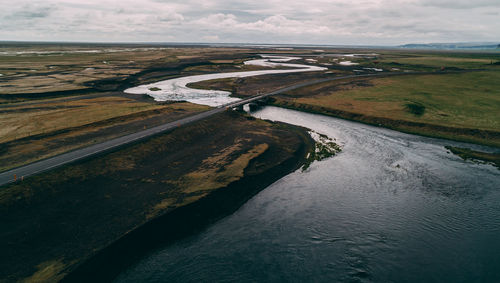 High angle view of river amidst land against sky