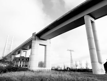 Low angle view of bridge amidst buildings against sky