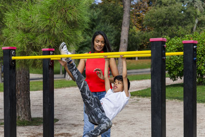Mother and son enjoying playing at the playground in the park.