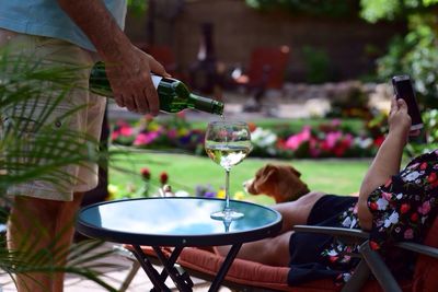 Midsection of man pouring wine in glass