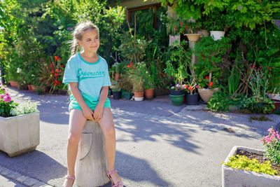 Girl sits and waits for a bus in typical european small village, summer family travel