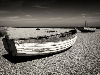 Boat moored on beach against sky