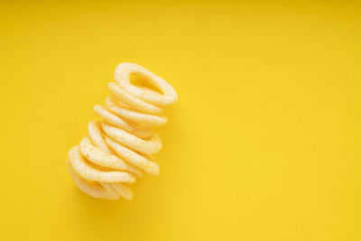 Close-up of ice cream cone against yellow background