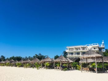 Scenic view of beach against clear blue sky