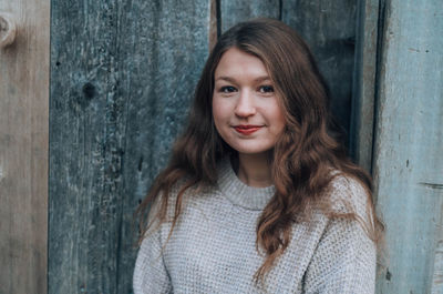 Portrait of smiling woman against wall