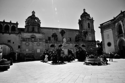 People on street amidst buildings in city