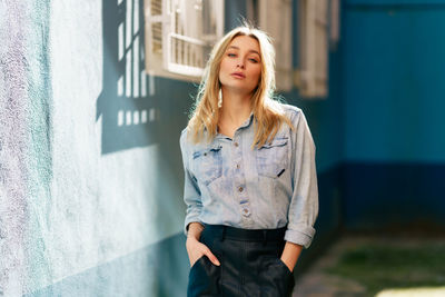 Portrait of beautiful woman standing against wall