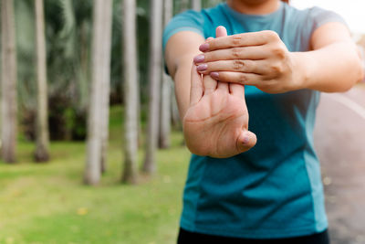 Sport woman stretching forearm before exercising. outdoor sport