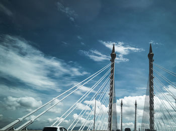 Low angle view of suspension bridge against sky