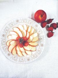 Directly above view of fresh apple slices with strawberries served in plate