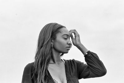 Portrait of young woman looking away against white background