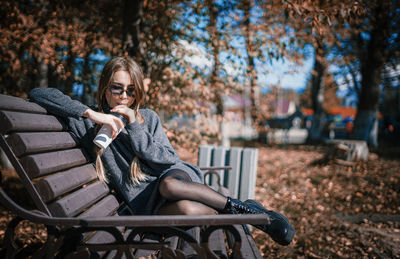 Portrait of woman sitting on bench in park