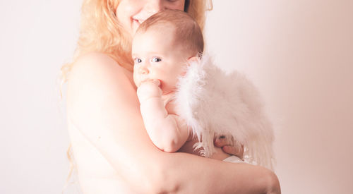Baby girl holding hands against white background