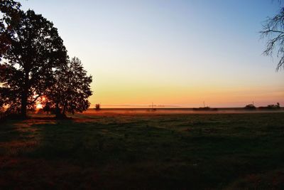 Scenic view of field against clear sky during sunset