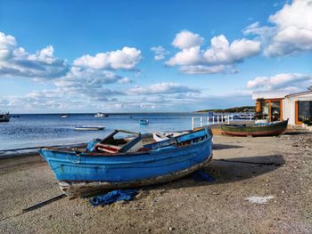 Boats moored on beach against sky