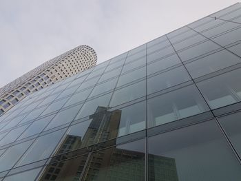 Low angle view of modern glass building against sky