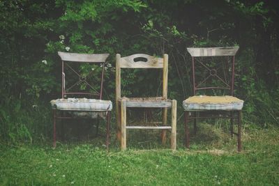 Empty chairs and table on field