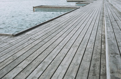 Close-up of pier over river against sky